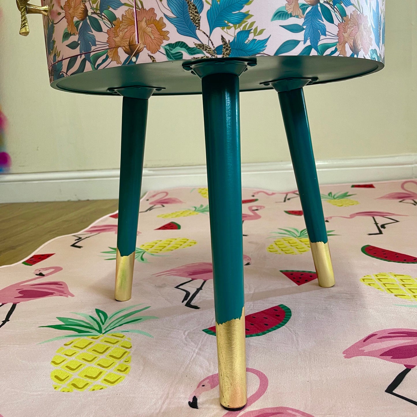 Floral - pink and green wooden round side table with leaf and flower design. Inbuilt drawer and three legs with gold painted palm tree handle