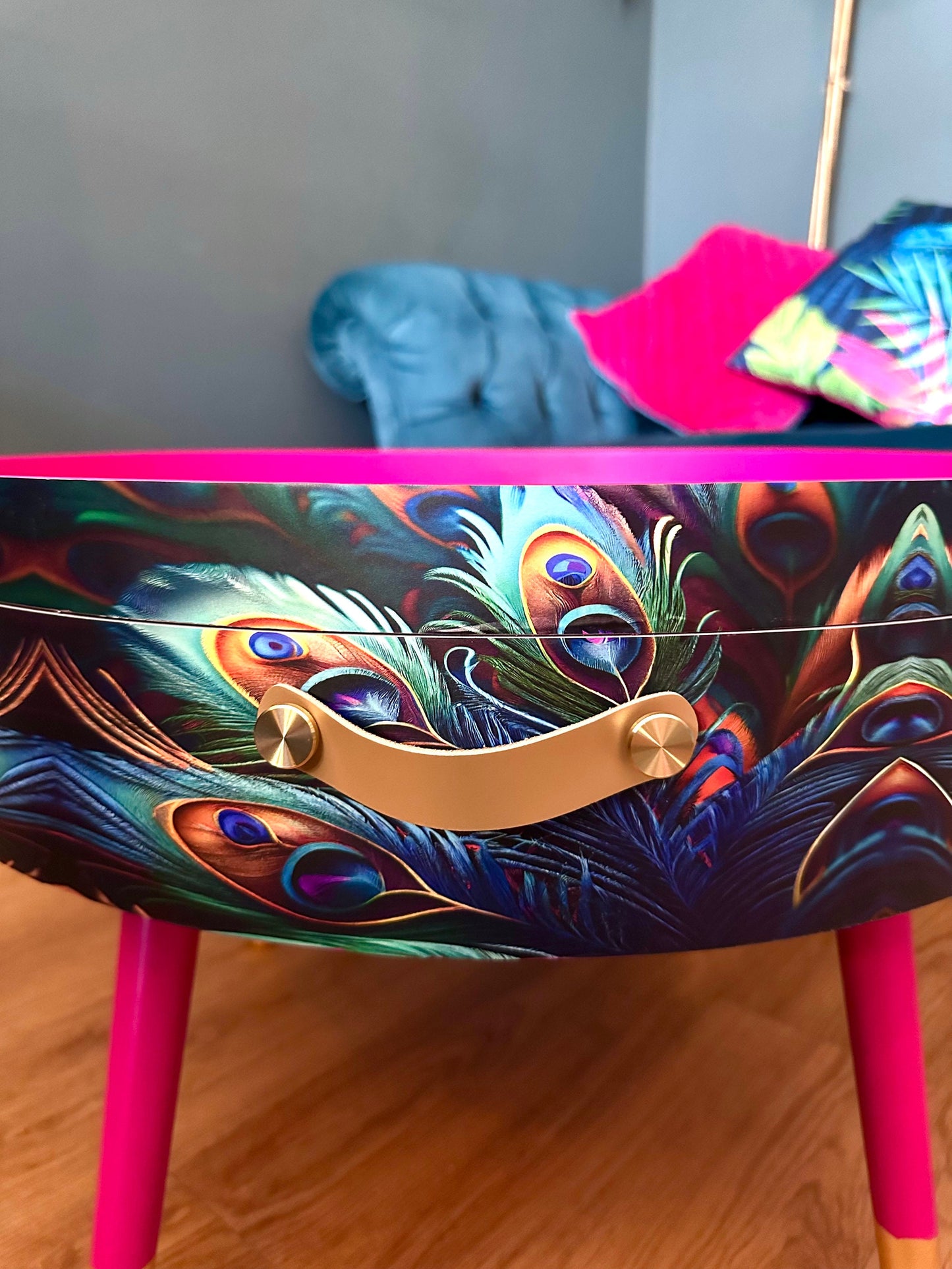 Round coffee table , peacock design, blue, teal and turquoise feathers. Bright pink. Round table, lift off top for storage. End table lounge