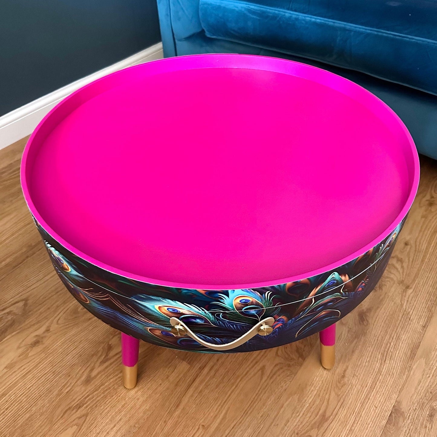 Round coffee table , peacock design, blue, teal and turquoise feathers. Bright pink. Round table, lift off top for storage. End table lounge