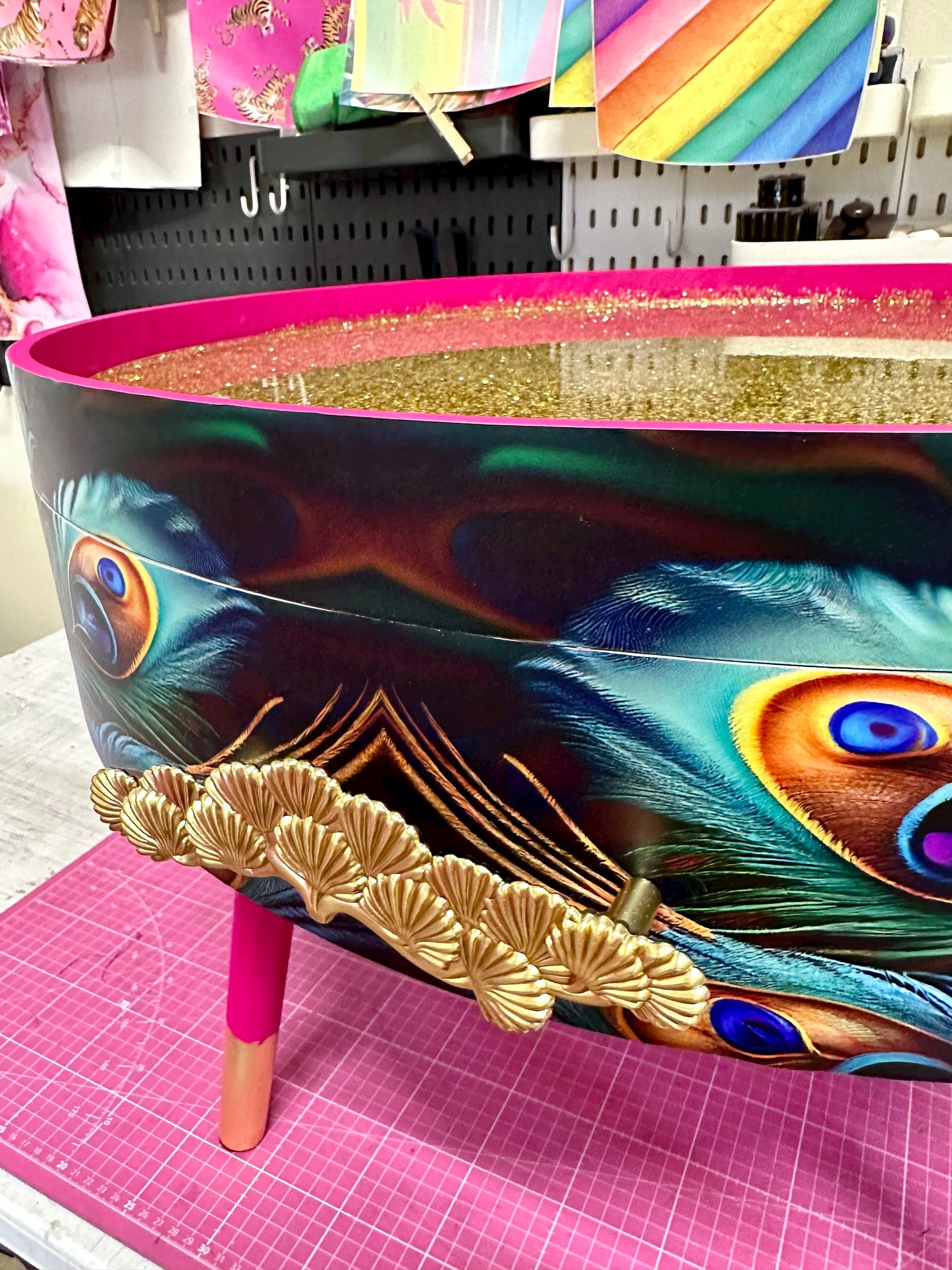 Round coffee table , peacock design, blue, teal and turquoise feathers. Bright pink. Round table, lift off top for storage. End table lounge
