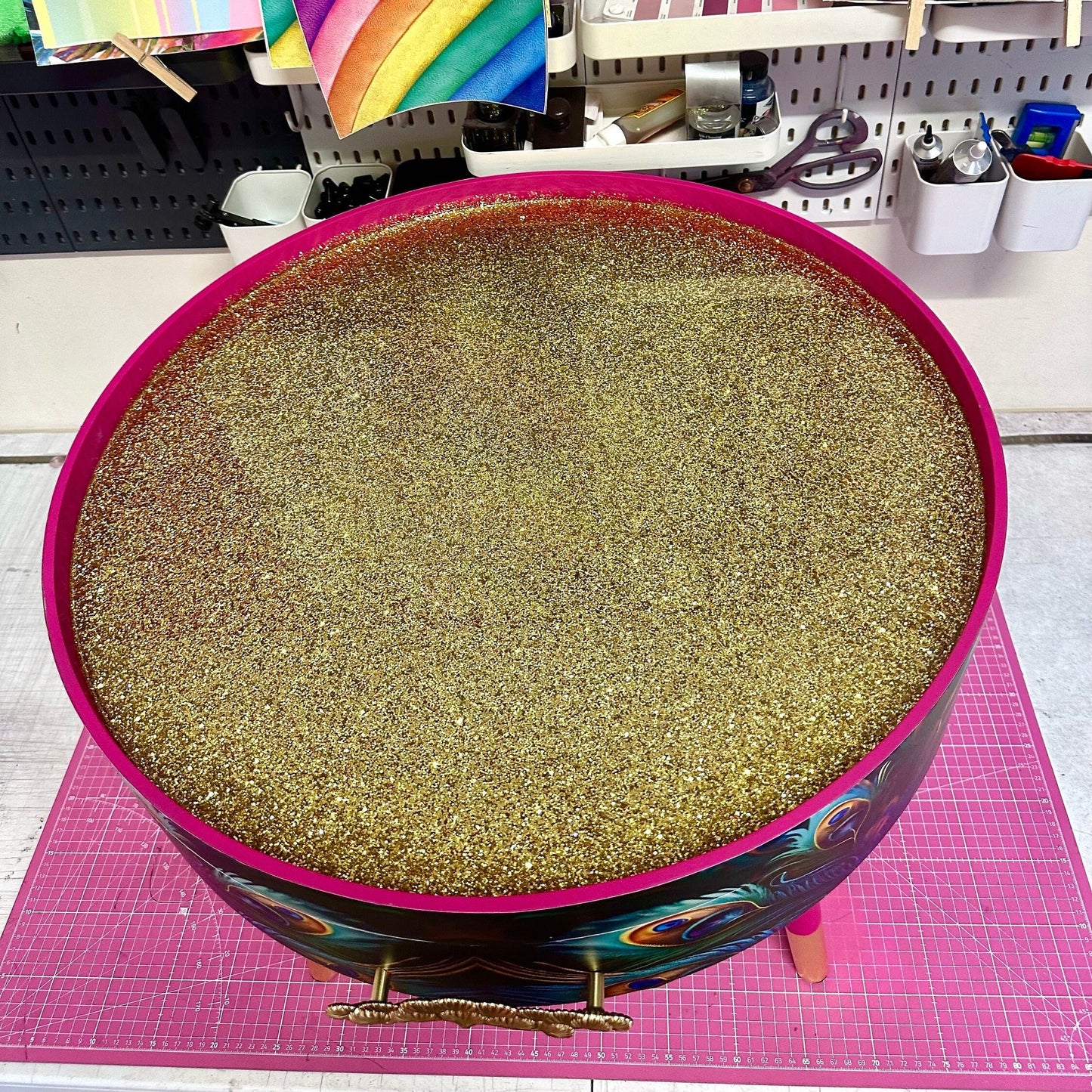 Round coffee table , peacock design, blue, teal and turquoise feathers. Bright pink. Round table, lift off top for storage. End table lounge