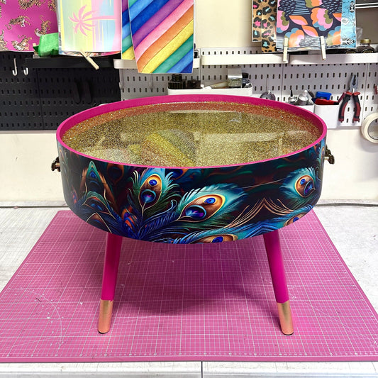 Round coffee table , peacock design, blue, teal and turquoise feathers. Bright pink. Round table, lift off top for storage. End table lounge