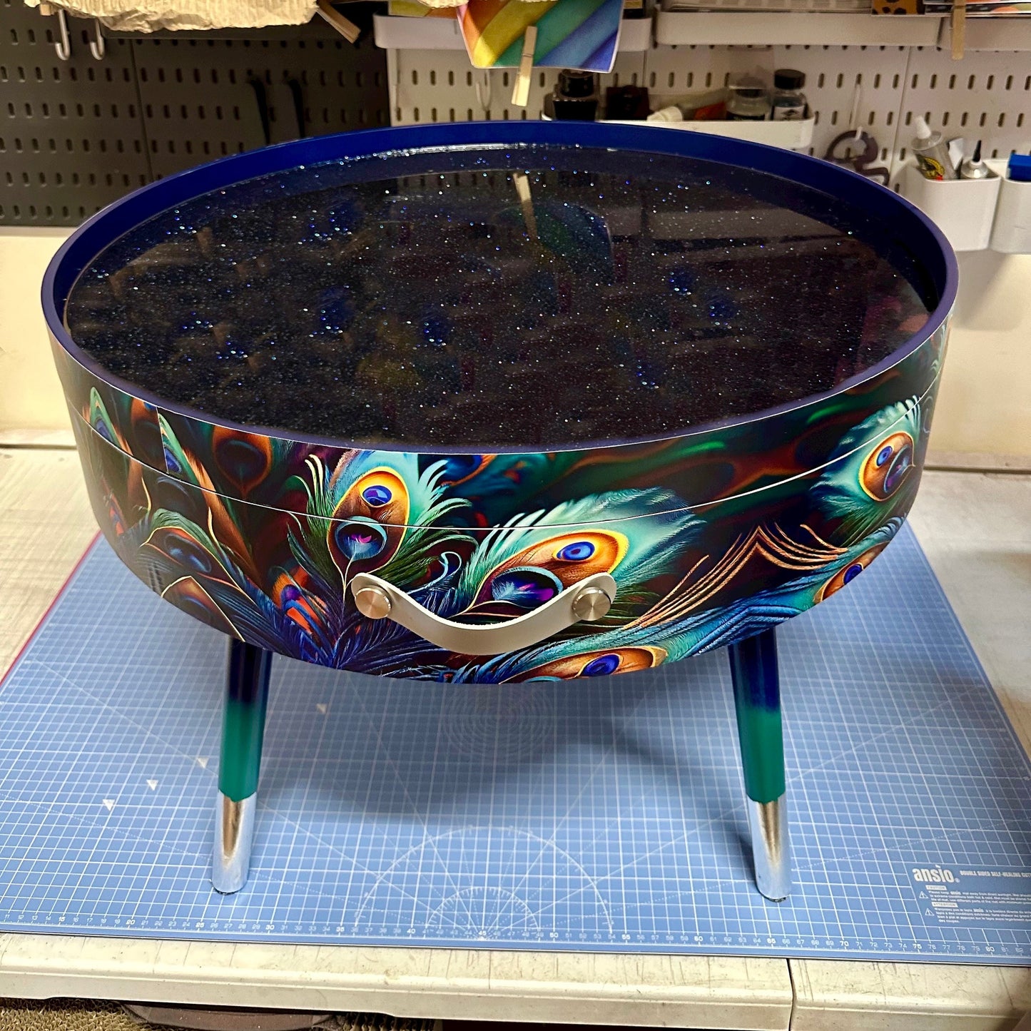 Round coffee table , peacock design, blue, teal  turquoise feathers. Navy Glitter . Round table, lift off top for storage. End table lounge