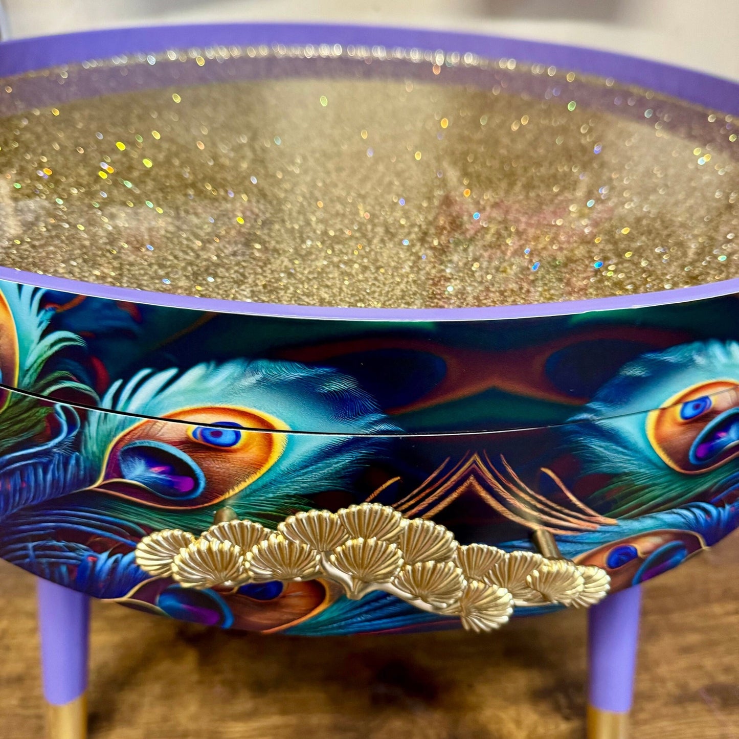 Round coffee table , peacock, blue, teal and turquoise feathers. Lilac purple gold glitter . Round table, storage, End table lounge