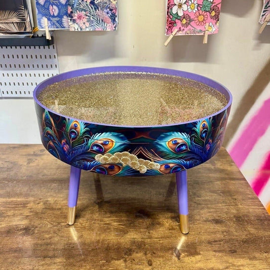 Round coffee table , peacock, blue, teal and turquoise feathers. Lilac purple gold glitter . Round table, storage, End table lounge