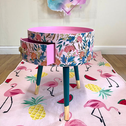 Floral - pink and green wooden round side table with leaf and flower design. Inbuilt drawer and three legs with gold painted palm tree handle