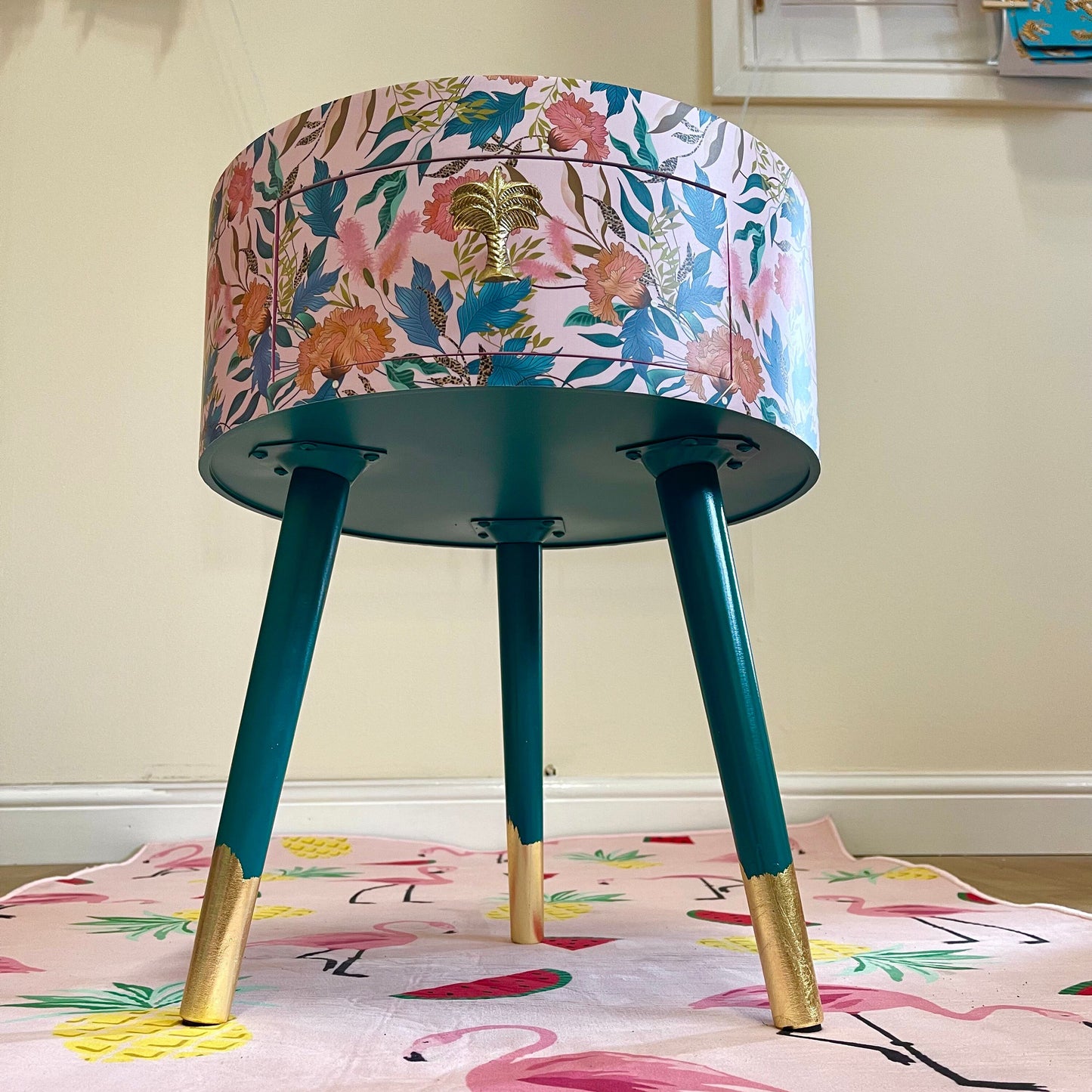 Floral - pink and green wooden round side table with leaf and flower design. Inbuilt drawer and three legs with gold painted palm tree handle