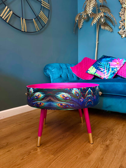 Round coffee table , peacock design, blue, teal and turquoise feathers. Bright pink. Round table, lift off top for storage. End table lounge
