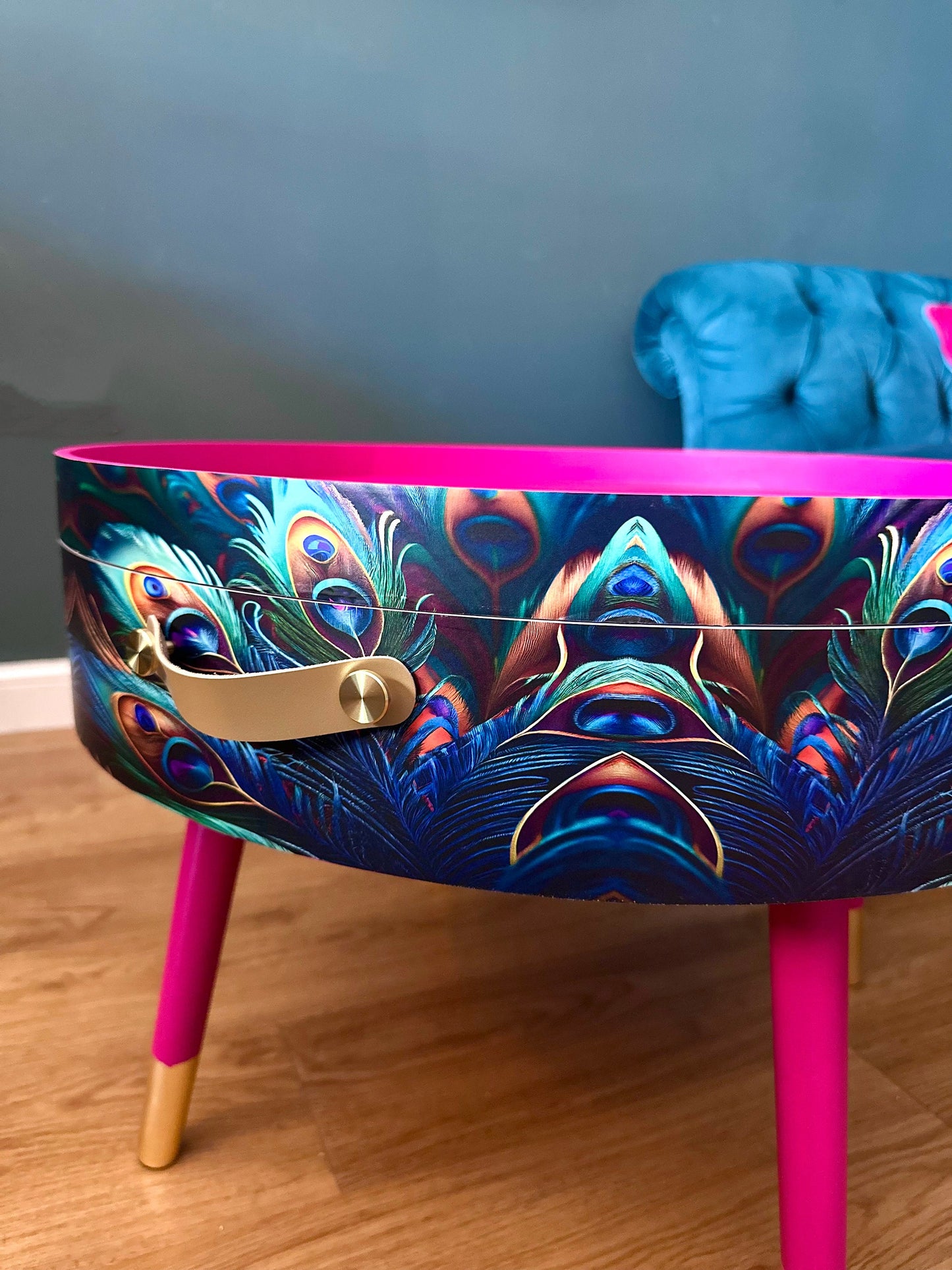 Round coffee table , peacock design, blue, teal and turquoise feathers. Bright pink. Round table, lift off top for storage. End table lounge
