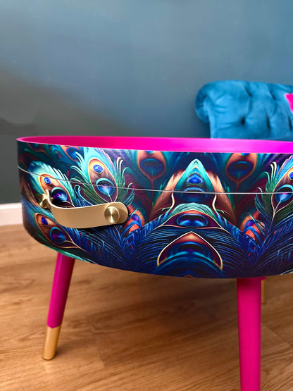 Round coffee table , peacock design, blue, teal and turquoise feathers. Bright pink. Round table, lift off top for storage. End table lounge