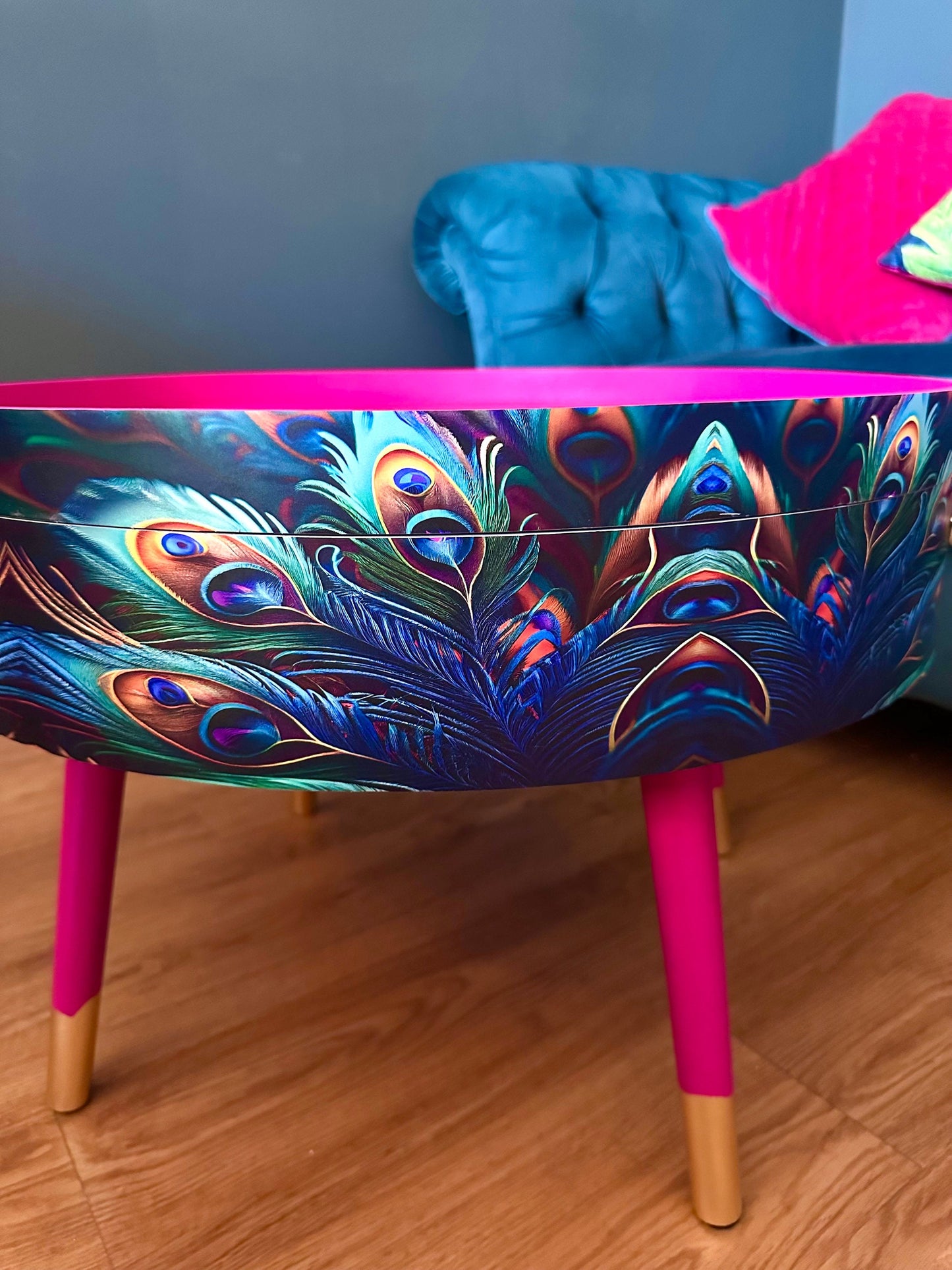 Round coffee table , peacock design, blue, teal and turquoise feathers. Bright pink. Round table, lift off top for storage. End table lounge
