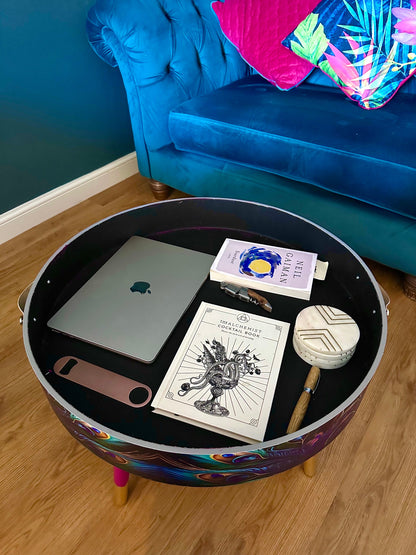 Round coffee table , peacock design, blue, teal and turquoise feathers. Bright pink. Round table, lift off top for storage. End table lounge