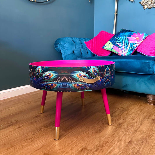 Round coffee table , peacock design, blue, teal and turquoise feathers. Bright pink. Round table, lift off top for storage. End table lounge