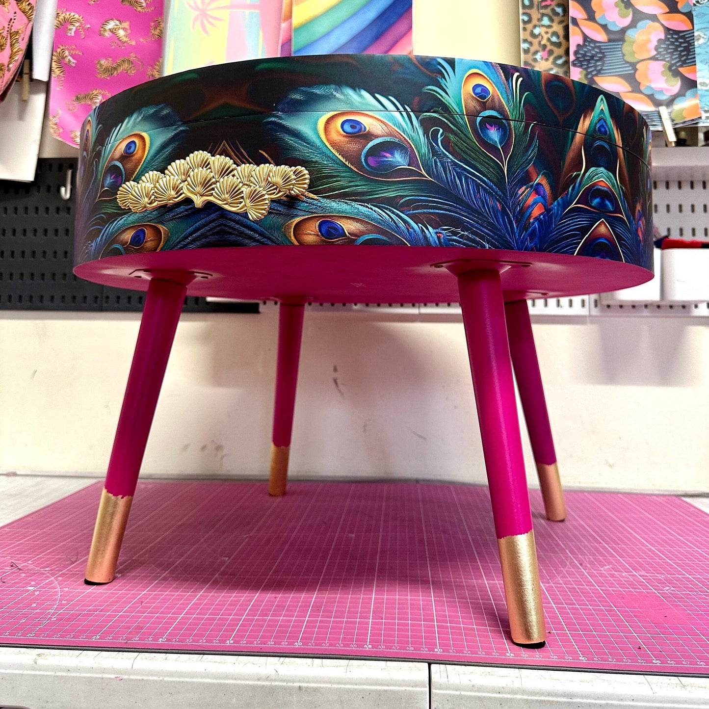 Round coffee table , peacock design, blue, teal and turquoise feathers. Bright pink. Round table, lift off top for storage. End table lounge