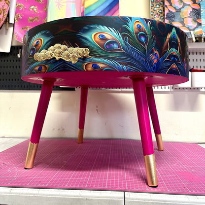 Round coffee table , peacock design, blue, teal and turquoise feathers. Bright pink. Round table, lift off top for storage. End table lounge
