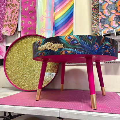 Round coffee table , peacock design, blue, teal and turquoise feathers. Bright pink. Round table, lift off top for storage. End table lounge