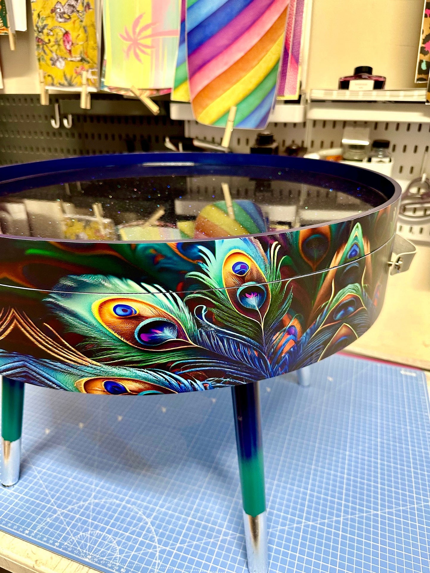 Round coffee table , peacock design, blue, teal  turquoise feathers. Navy Glitter . Round table, lift off top for storage. End table lounge