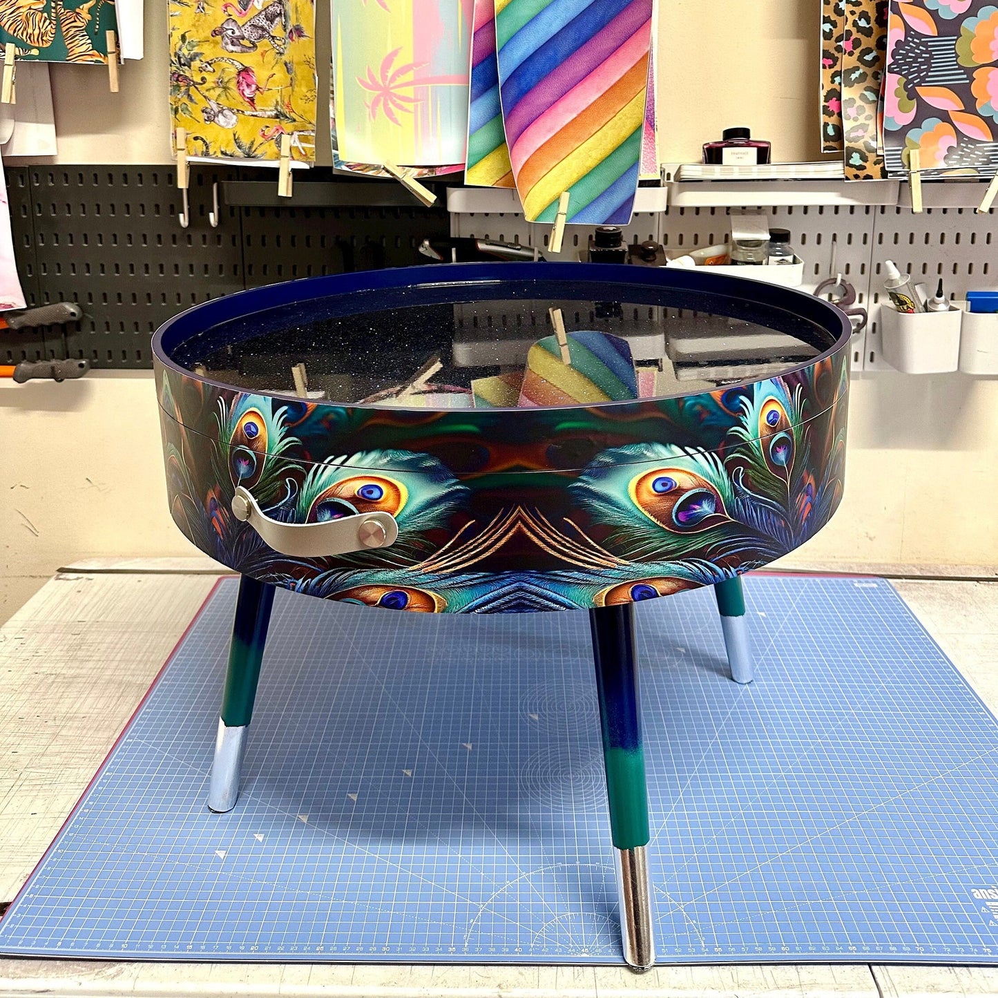 Round coffee table , peacock design, blue, teal  turquoise feathers. Navy Glitter . Round table, lift off top for storage. End table lounge