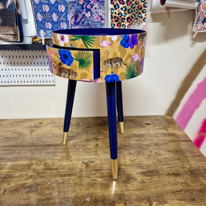Flocking Fab - Yellow and navy round bedside table. Tropical design nightstand with flamingo and leopards. Cheetah and floral end table