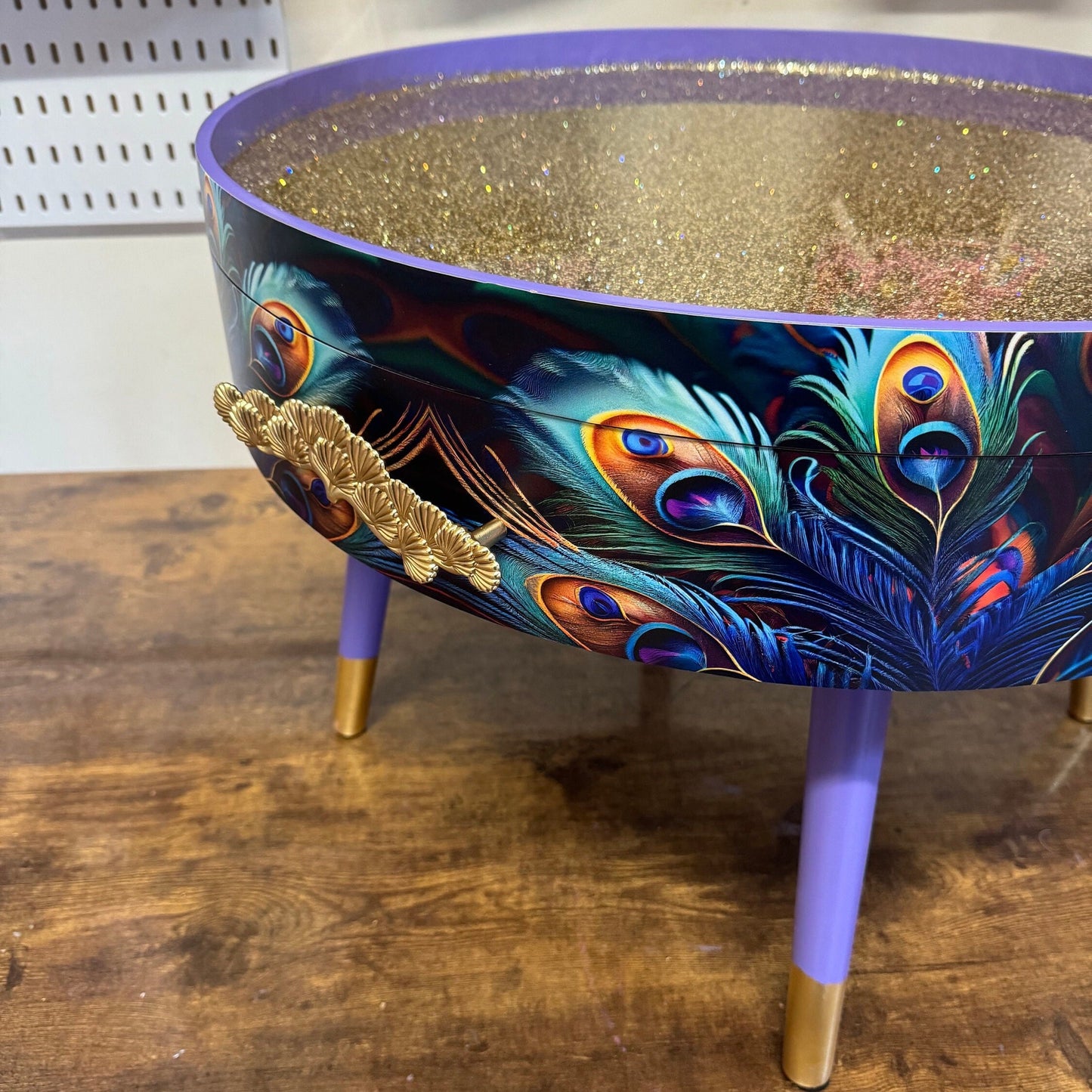 Round coffee table , peacock, blue, teal and turquoise feathers. Lilac purple gold glitter . Round table, storage, End table lounge
