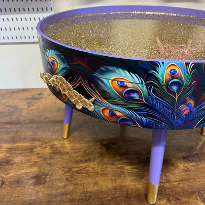 Round coffee table , peacock, blue, teal and turquoise feathers. Lilac purple gold glitter . Round table, storage, End table lounge