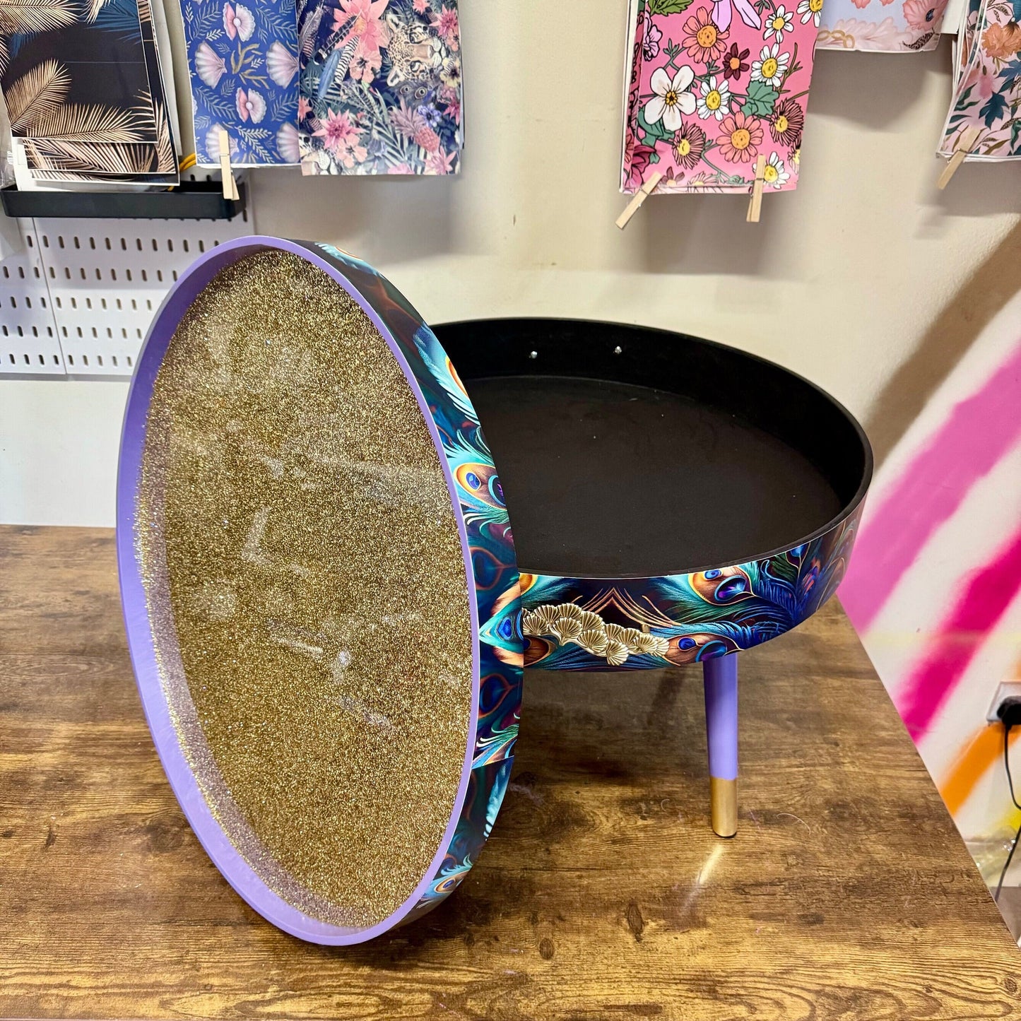 Round coffee table , peacock, blue, teal and turquoise feathers. Lilac purple gold glitter . Round table, storage, End table lounge