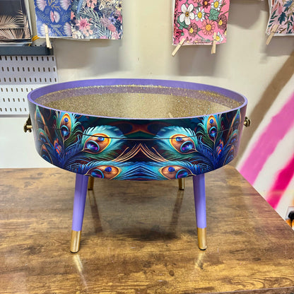 Round coffee table , peacock, blue, teal and turquoise feathers. Lilac purple gold glitter . Round table, storage, End table lounge