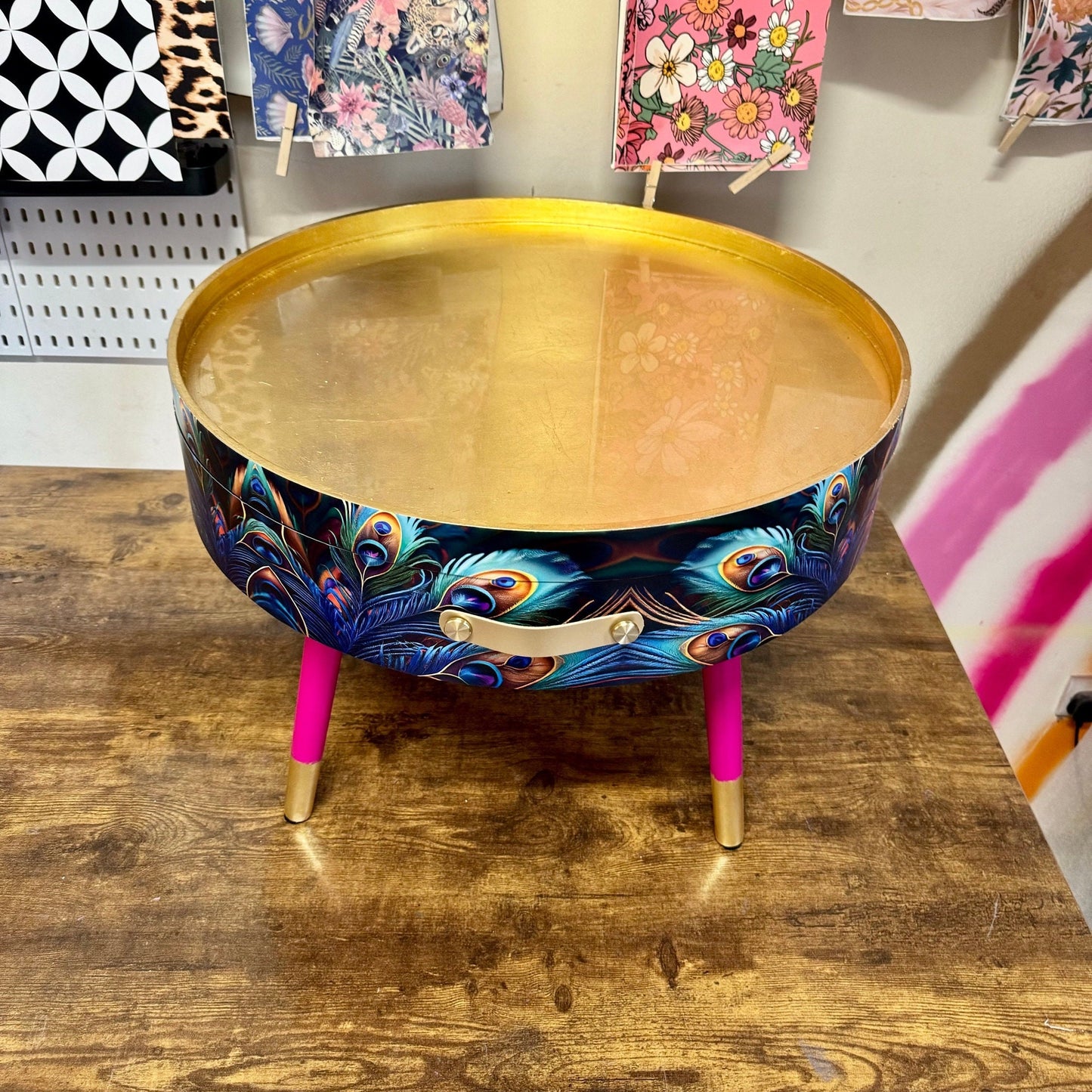 Round coffee table , peacock design, blue, teal and turquoise feathers. Bright pink and gold, lift off top for storage. End table lounge