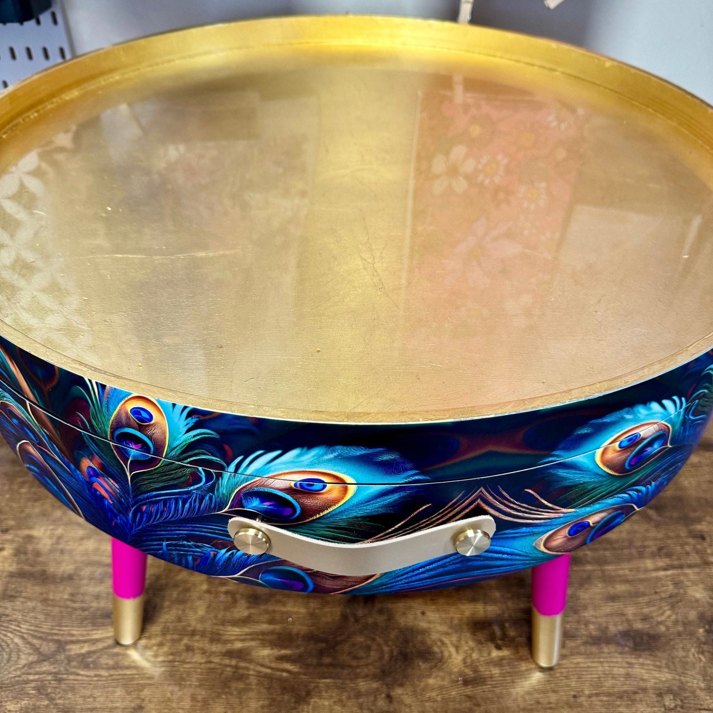 Round coffee table , peacock design, blue, teal and turquoise feathers. Bright pink and gold, lift off top for storage. End table lounge
