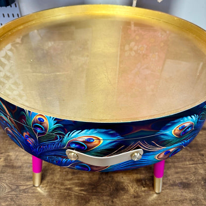 Round coffee table , peacock design, blue, teal and turquoise feathers. Bright pink and gold, lift off top for storage. End table lounge