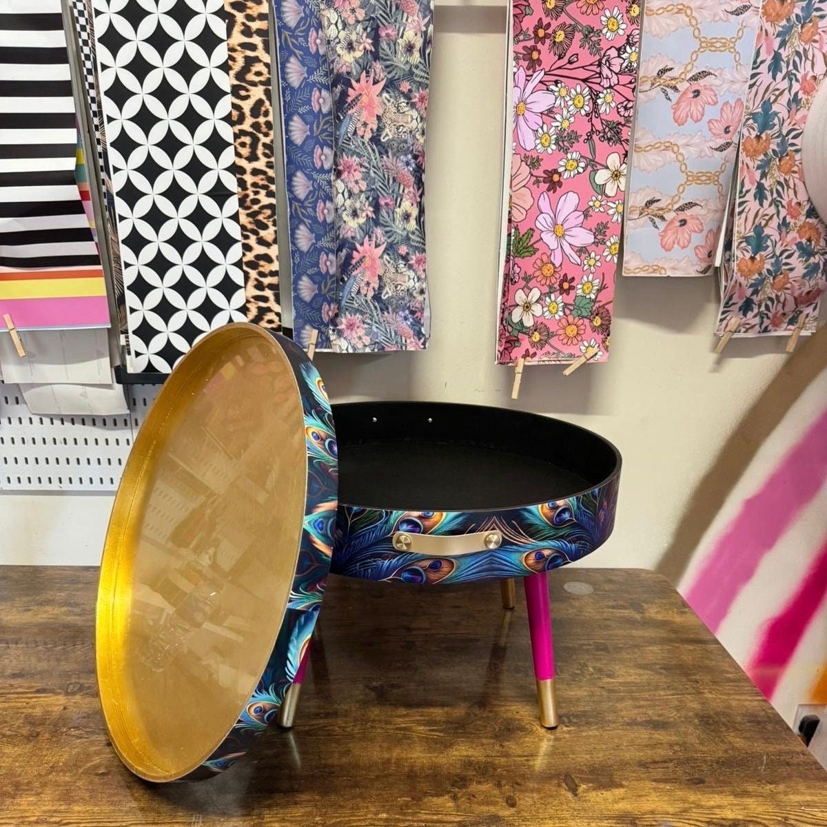 Round coffee table , peacock design, blue, teal and turquoise feathers. Bright pink and gold, lift off top for storage. End table lounge