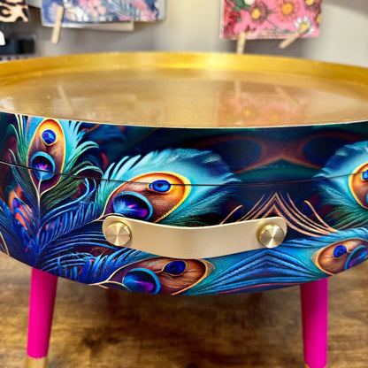 Round coffee table , peacock design, blue, teal and turquoise feathers. Bright pink and gold, lift off top for storage. End table lounge