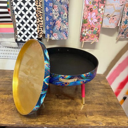Round coffee table , peacock design, blue, teal and turquoise feathers. Bright pink and gold, lift off top for storage. End table lounge