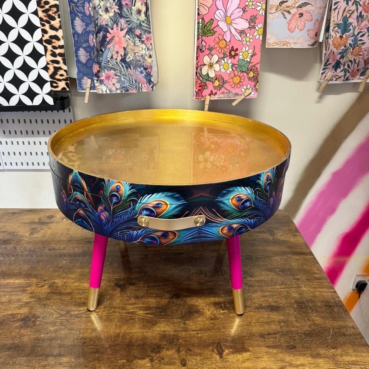 Round coffee table , peacock design, blue, teal and turquoise feathers. Bright pink and gold, lift off top for storage. End table lounge